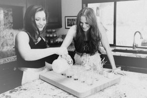 Maria and Megan hand pouring soy wax candles
